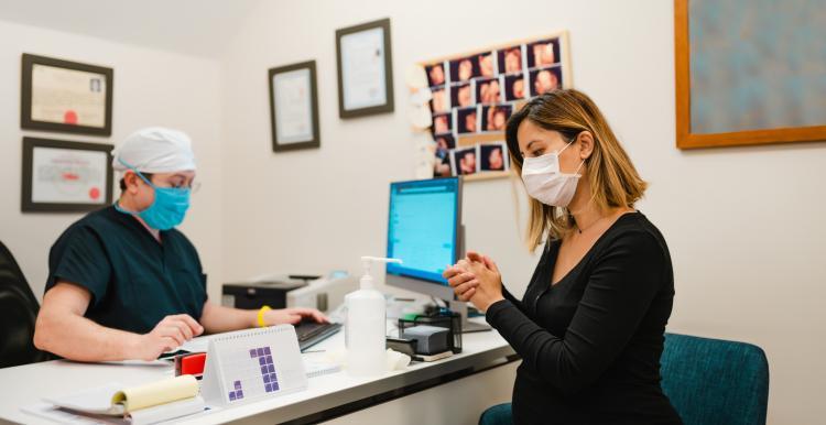 Image of pregnant lady wearing a mask at a doctor's appointment