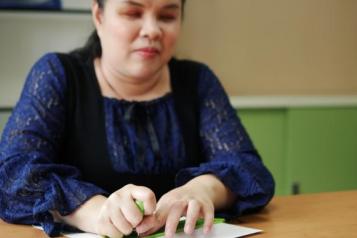 Image of blind woman using braille