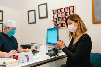 Image of pregnant lady wearing a mask at a doctor's appointment