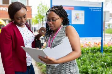 Image of two people looking at a folder outside a hospital