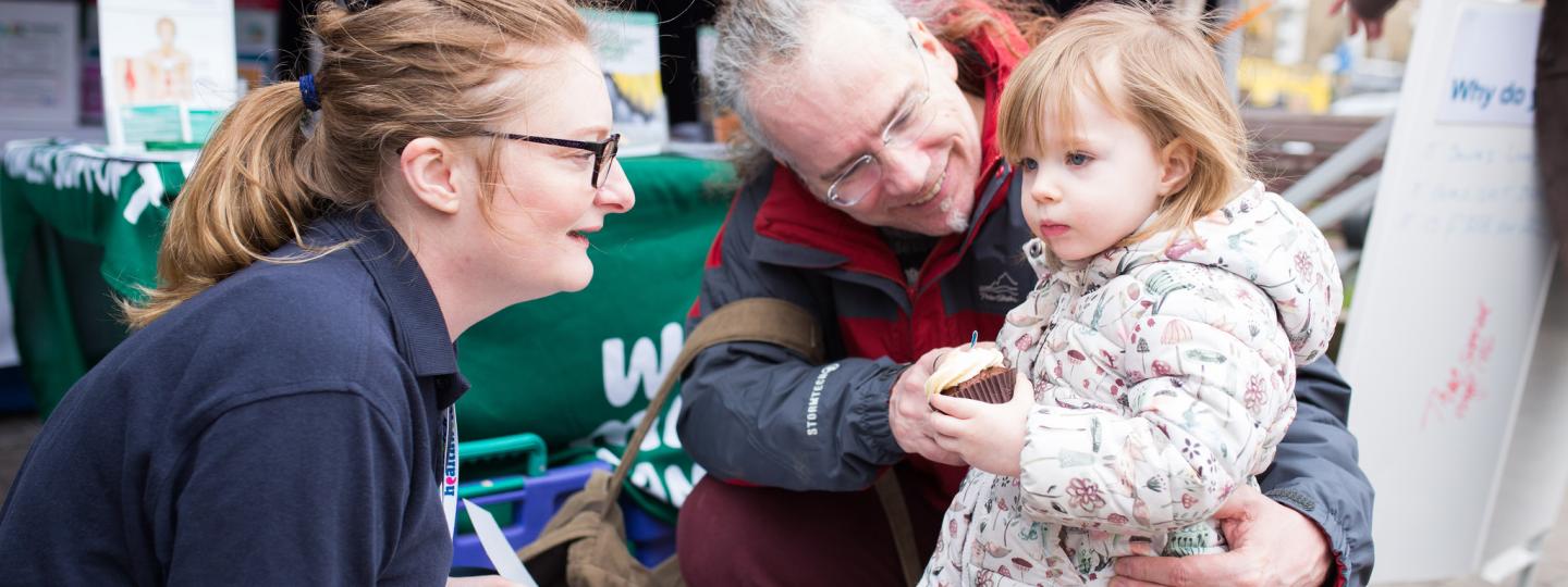 Healthwatch Volunteer talking to a little girl and her dad