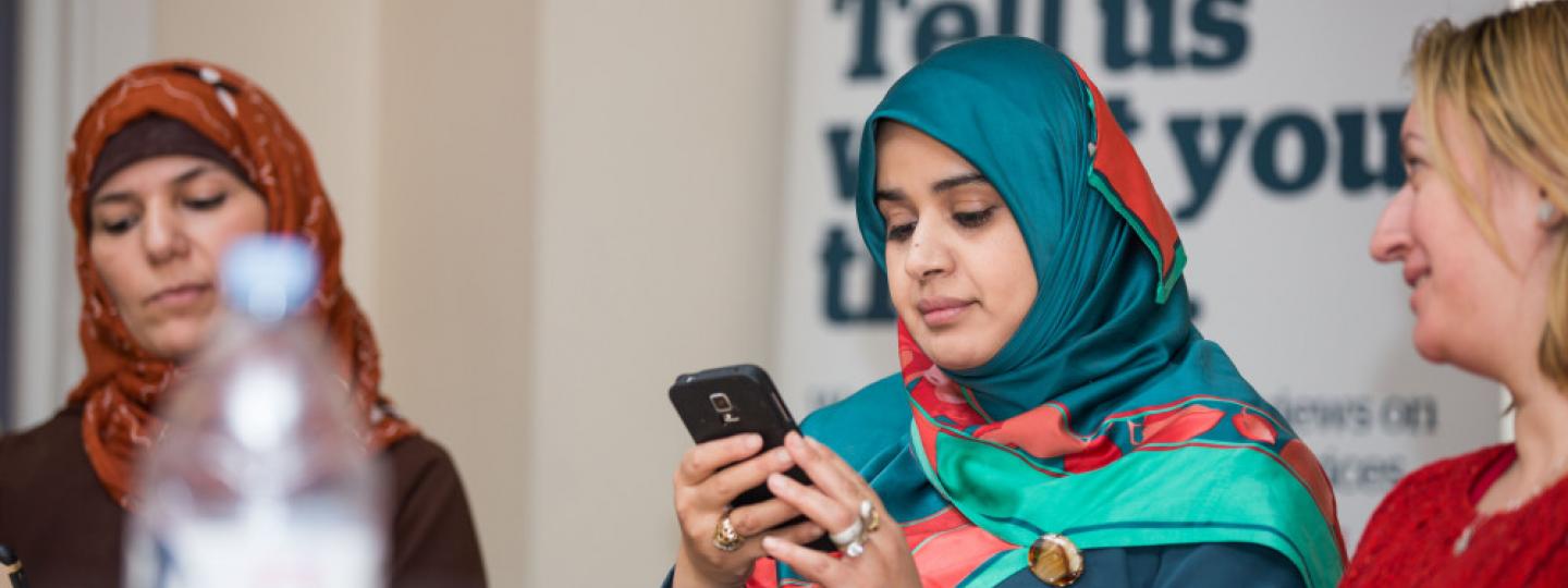 Image of woman on mobile phone with other people