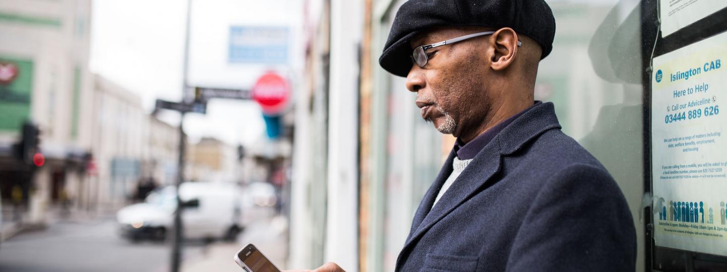 man holding a phone outside a building